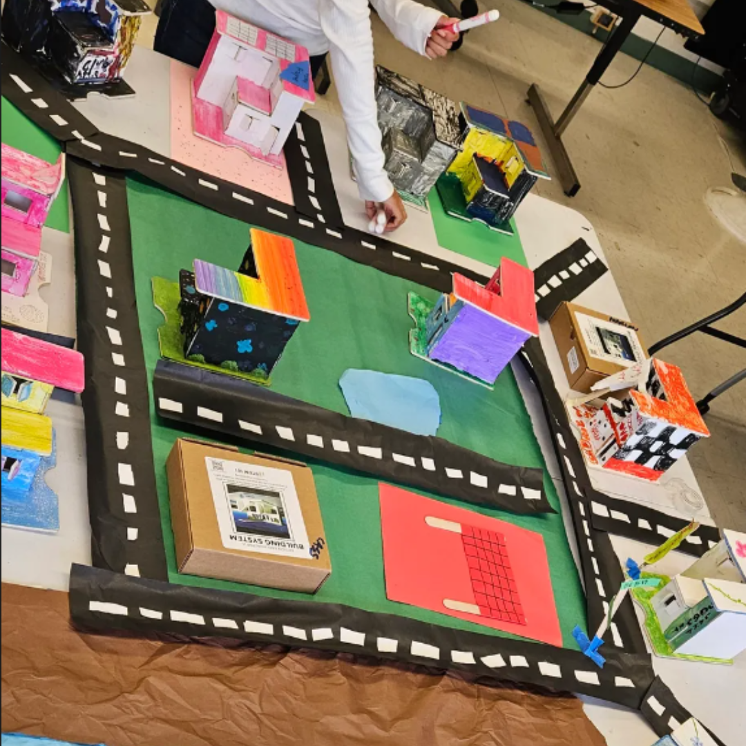 Kids build a model building from a STEM project to explore temperature and humidity control.