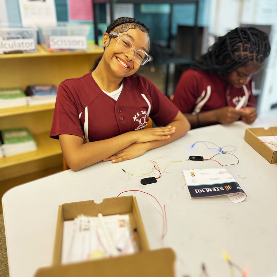 Kids assembling a circuitry game from a STEM project, exploring electrical engineering concepts.