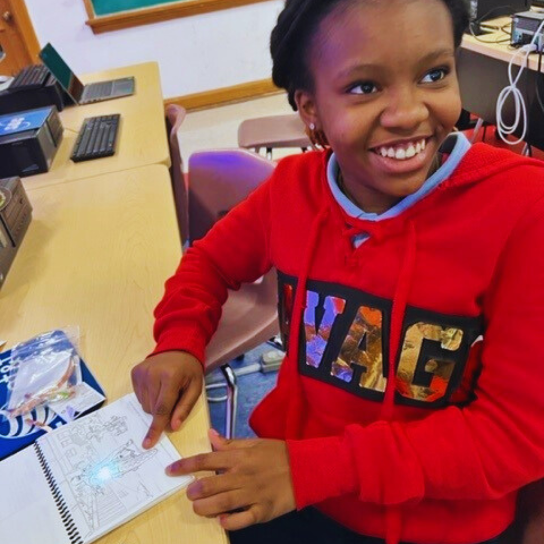 Kids building circuits with glowing Harley-Davidson models from a STEM kit.
