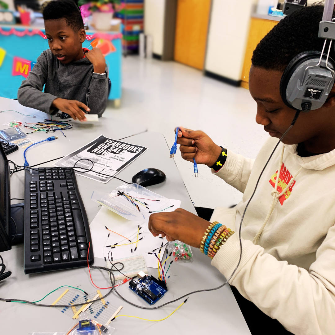 Kids building and coding a marble maze from a STEM project, exploring electronics and technology.