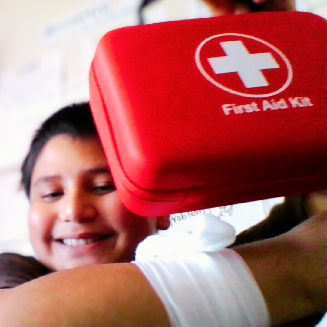 Kids practicing first aid techniques from a STEM kit, using real medical supplies.