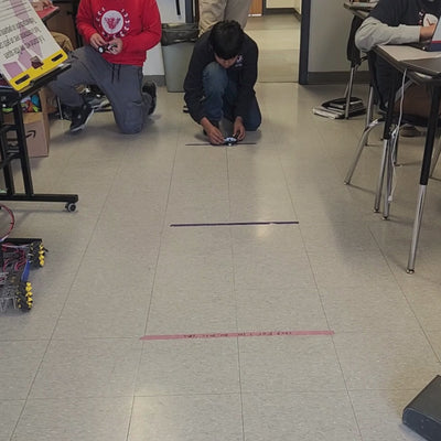 Kids assemble an autonomous vehicle from a STEM kit, exploring robotics and engineering skills.
