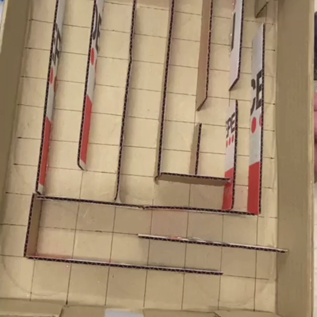 Kids building and coding a marble maze from a STEM project, exploring electronics and technology.